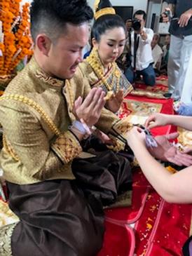 新郎新婦の手首に白い木綿の糸が結ばれます(筆者撮影)